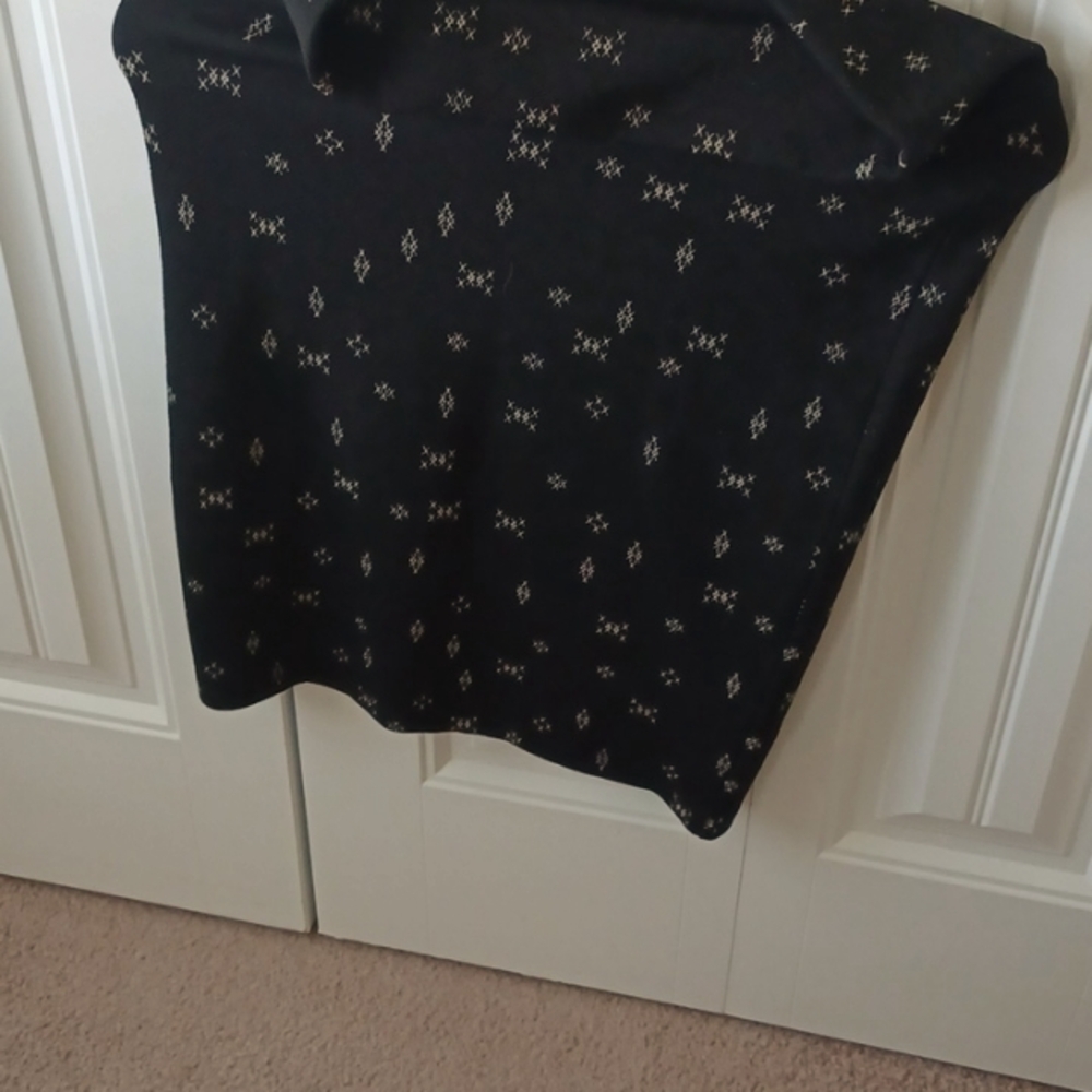 A lularoe black skirt. It has cream colored x on it. It is an XS